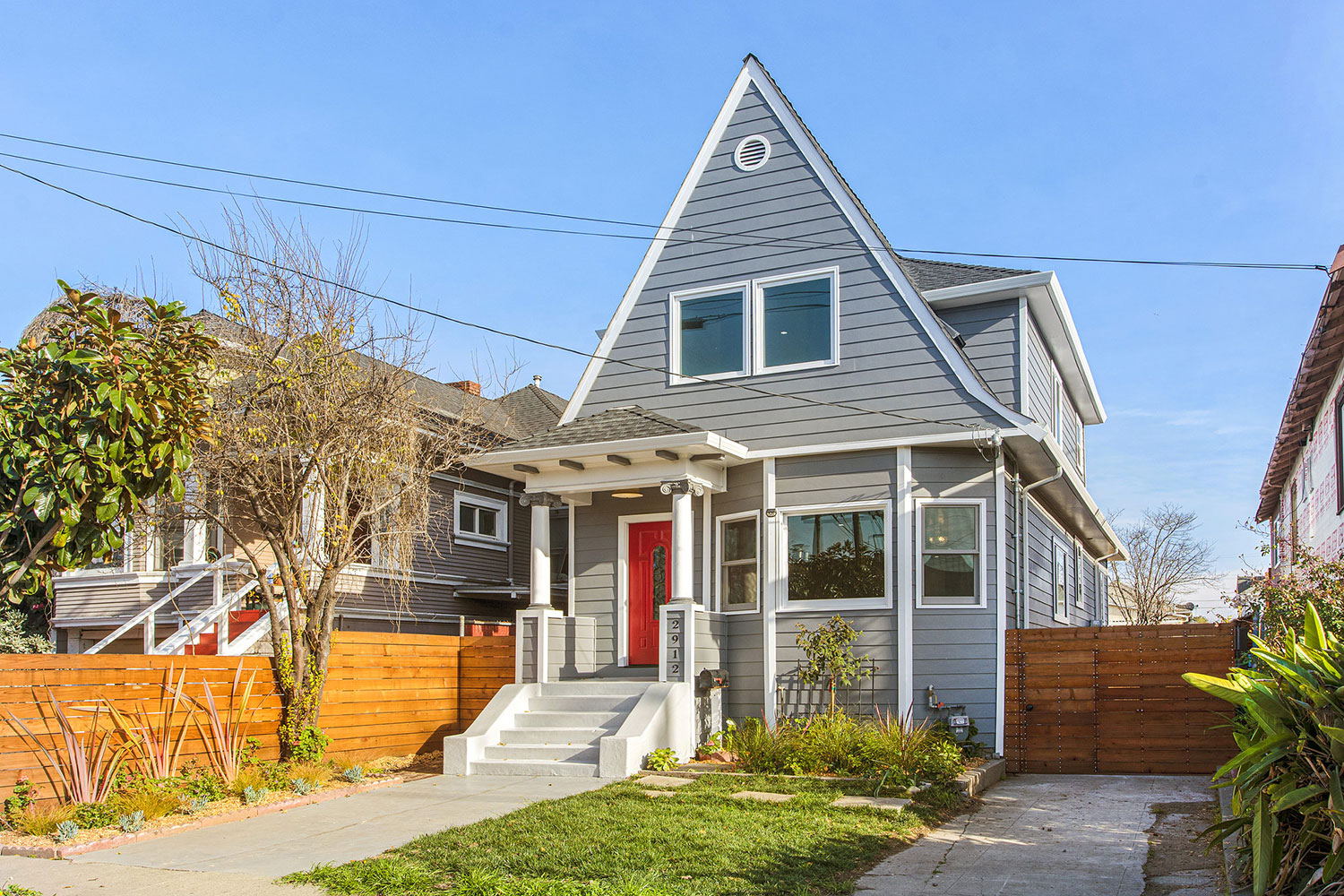 A-frame 2-story house originally built in 1905. Fully renovated in 2020. Victorian architecture period details. Exterior painted gray with white trim. Red entry door.