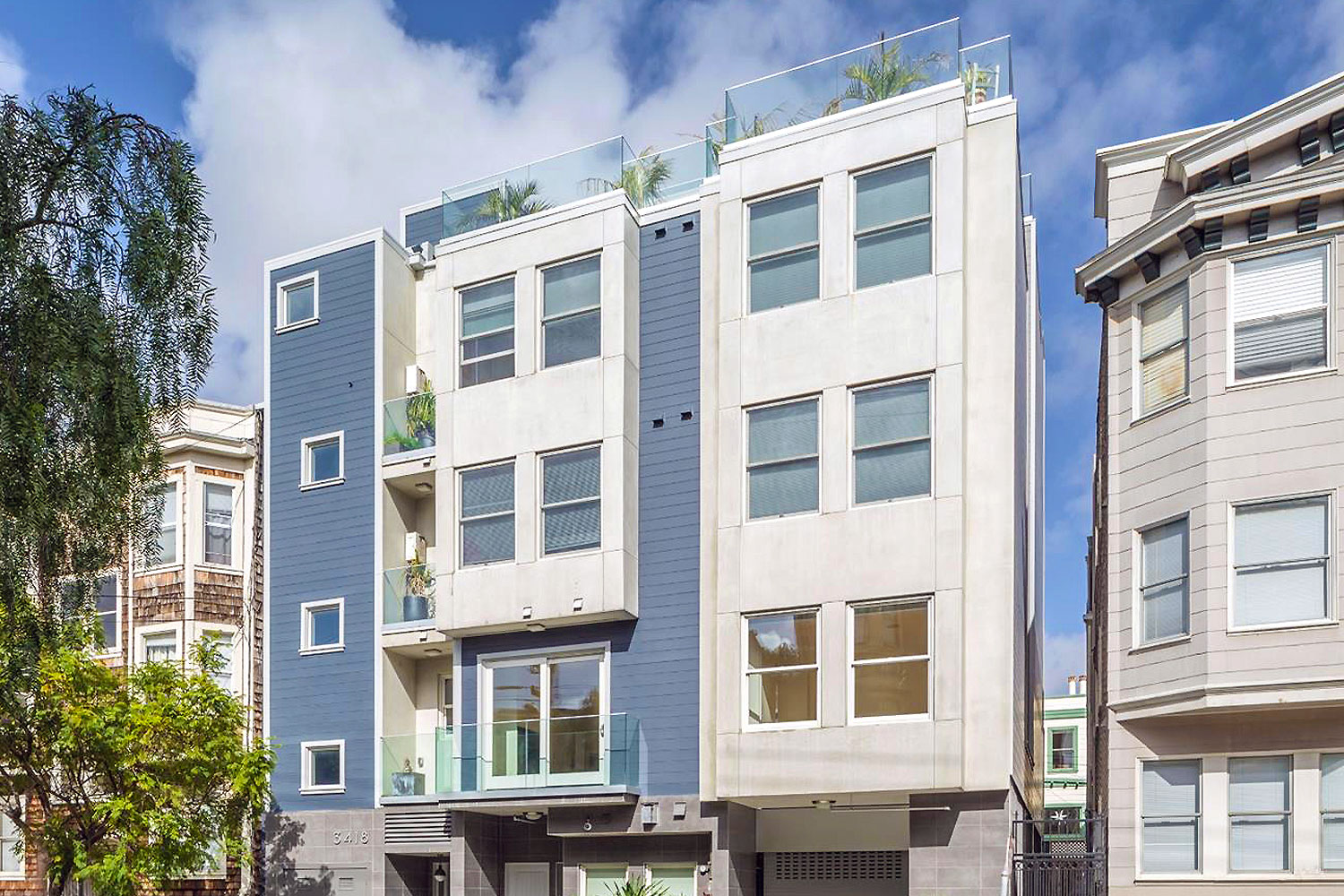 5-story building with 11 units, rooftop deck, and garage parking. New construction features. Painted light blue with white trim.
